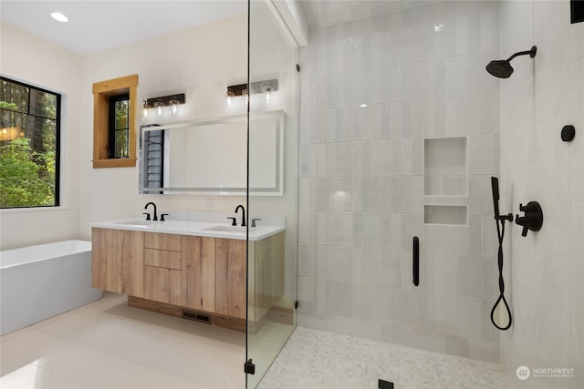 bathroom with shower with separate bathtub, vanity, and tile patterned floors