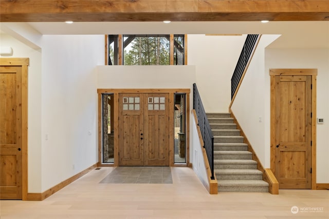 foyer featuring light hardwood / wood-style flooring and a towering ceiling