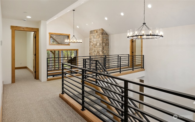 corridor featuring a chandelier, light colored carpet, and high vaulted ceiling