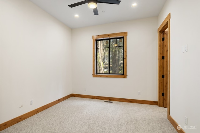 carpeted spare room with ceiling fan