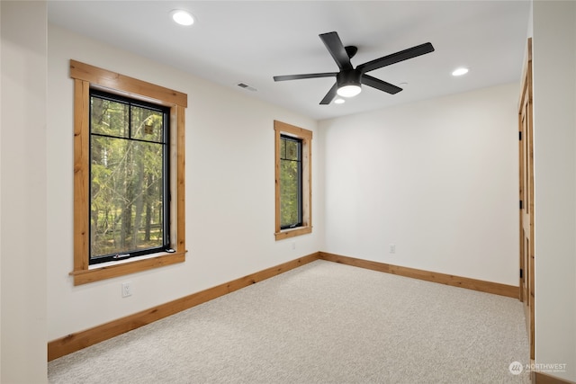 carpeted spare room featuring ceiling fan and plenty of natural light