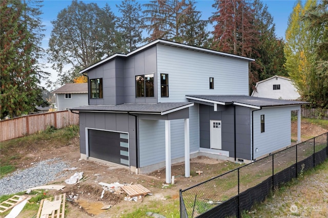 rear view of property with a garage