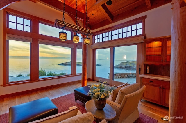 sunroom / solarium featuring beam ceiling, a wealth of natural light, a water view, and wooden ceiling