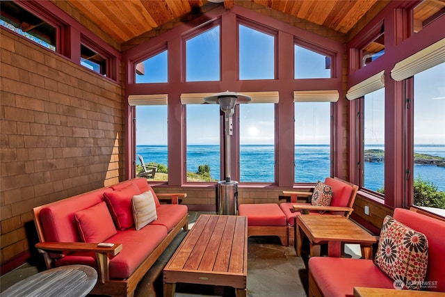 sunroom / solarium featuring lofted ceiling, plenty of natural light, and a water view