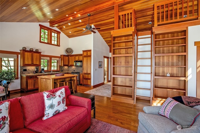 living room with ceiling fan, wood ceiling, dark hardwood / wood-style floors, and high vaulted ceiling