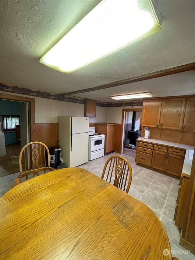 dining area with wood walls and a textured ceiling