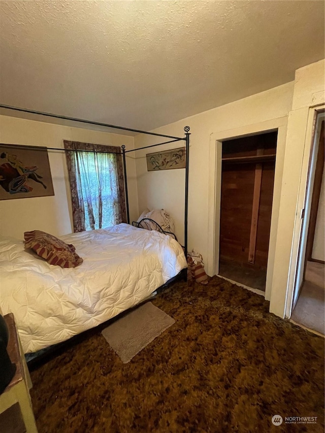 carpeted bedroom with a textured ceiling and a closet