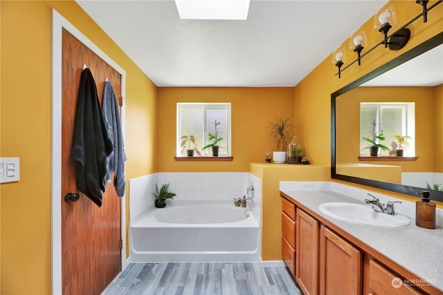 bathroom featuring a bath, hardwood / wood-style floors, and vanity