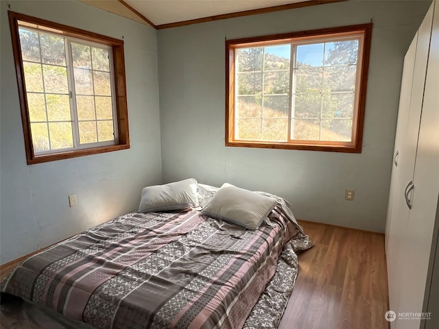 bedroom featuring ornamental molding and wood-type flooring