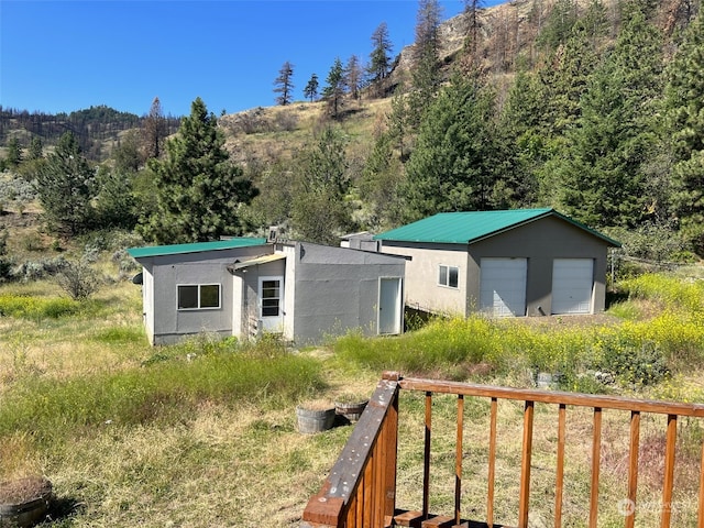 view of front of home with an outdoor structure, a garage, and a wooden deck