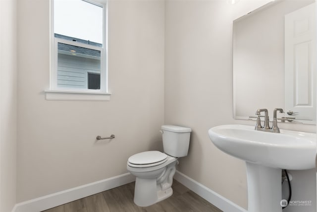 bathroom featuring hardwood / wood-style flooring and toilet