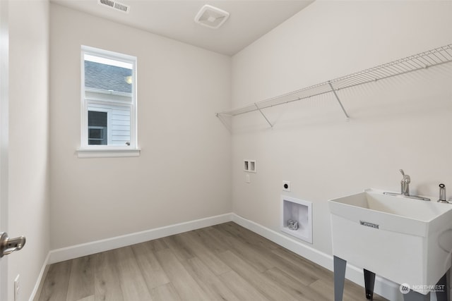 laundry area featuring hookup for an electric dryer, sink, washer hookup, and light hardwood / wood-style floors