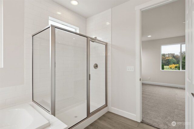 bathroom featuring independent shower and bath and hardwood / wood-style floors