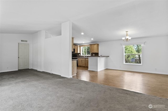 unfurnished living room with dark carpet and a chandelier