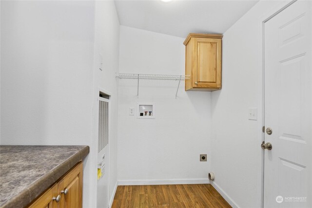 laundry room featuring cabinets, electric dryer hookup, washer hookup, and dark hardwood / wood-style flooring