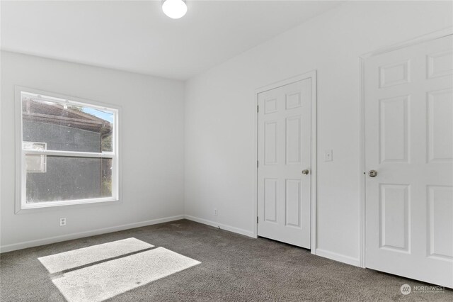 unfurnished bedroom featuring dark colored carpet