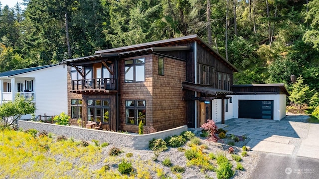 840 Shoshone Dr, La Conner, WA 98257 - view of front facade with an attached garage, concrete driveway, and a forest view