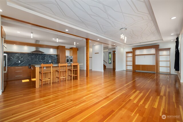 living room featuring light hardwood / wood-style floors and a raised ceiling