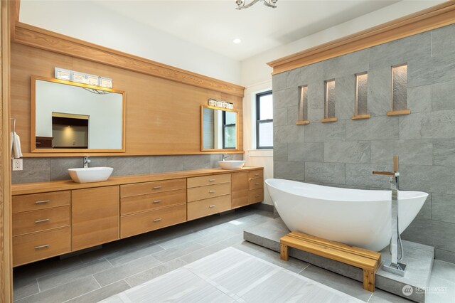 bathroom with tile walls, tile flooring, double sink, and oversized vanity