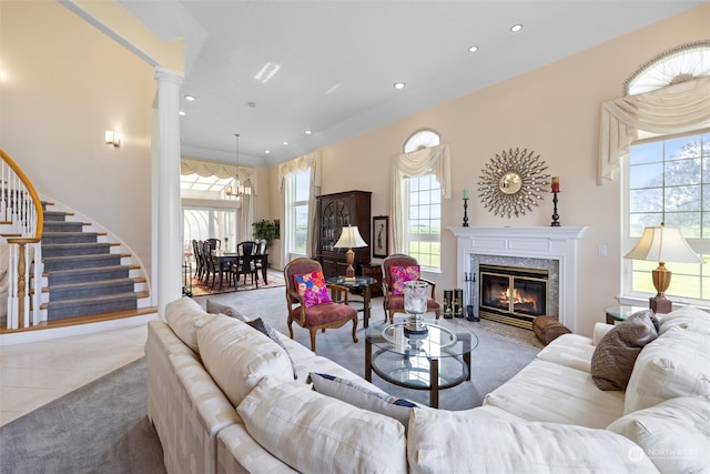 tiled living room with a notable chandelier, a premium fireplace, and ornate columns