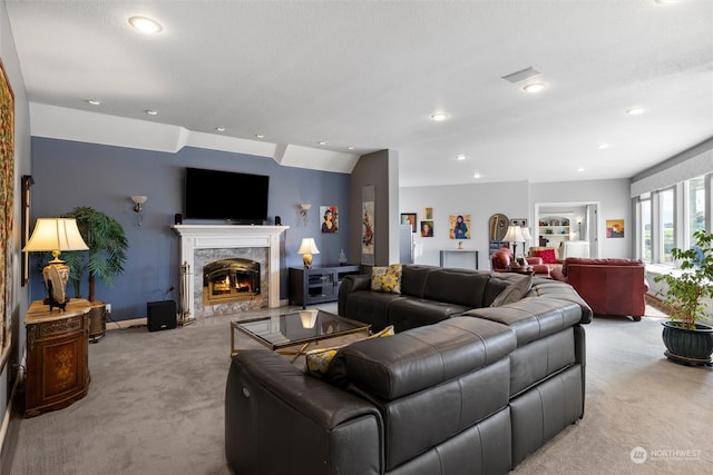 living room featuring a textured ceiling, a fireplace, lofted ceiling, and light carpet