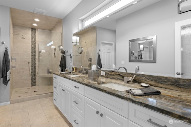 bathroom with vanity, tile patterned flooring, and a tile shower