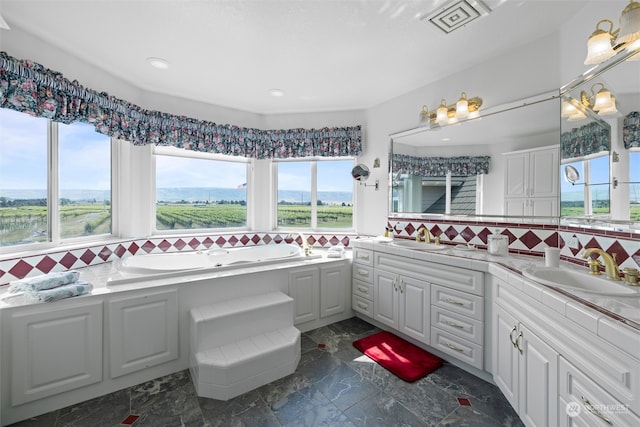 bathroom featuring decorative backsplash, vanity, a mountain view, and a washtub