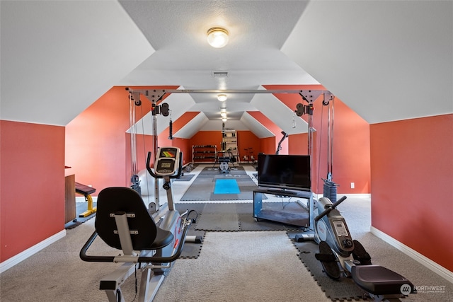 workout area featuring a textured ceiling, lofted ceiling, and light carpet