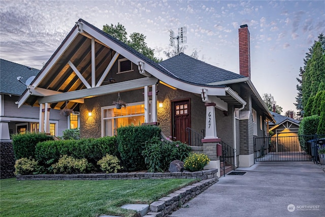 view of front facade with roof with shingles, a front lawn, a chimney, and a gate