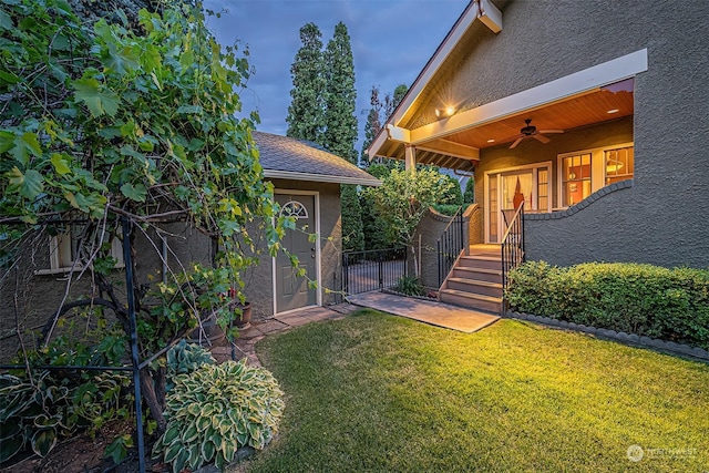 view of yard featuring a gate, fence, and a ceiling fan