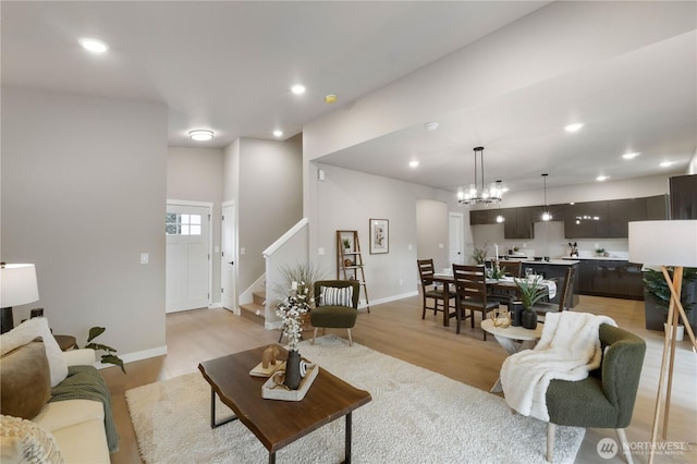 living room with stairs, light wood-style floors, baseboards, and recessed lighting