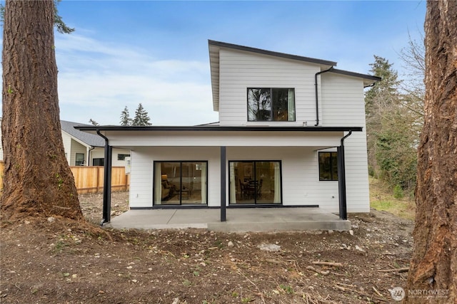 back of property featuring fence and a patio