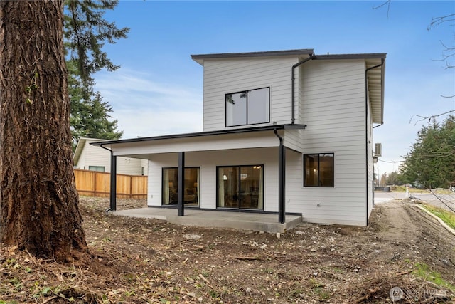 rear view of property featuring a patio area and fence