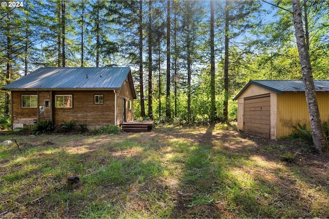 view of yard featuring a garage and an outdoor structure