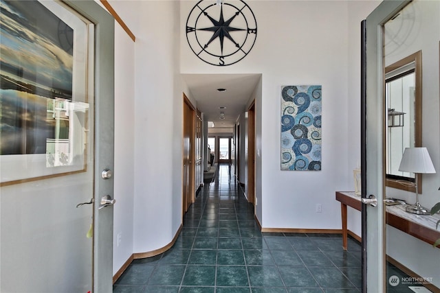 corridor featuring french doors and dark tile patterned floors