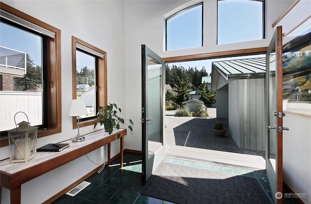 doorway to outside with dark tile patterned flooring