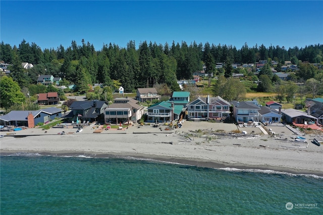 birds eye view of property with a water view and a beach view