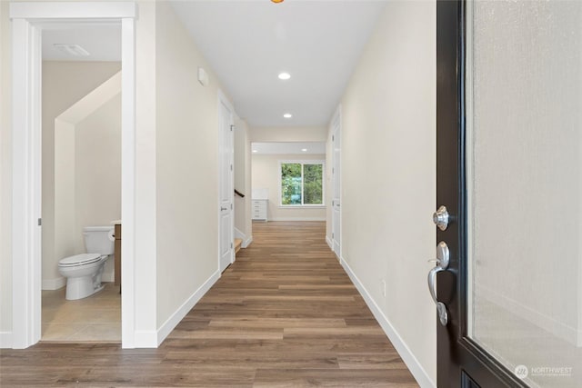 corridor with hardwood / wood-style flooring