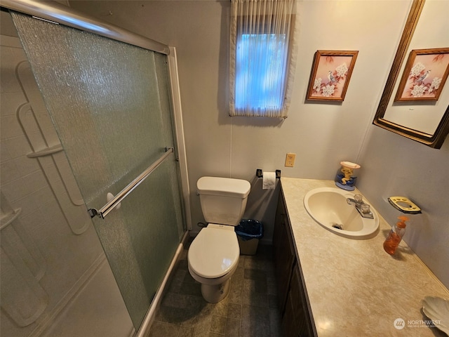 bathroom with toilet, vanity, and a shower with shower door