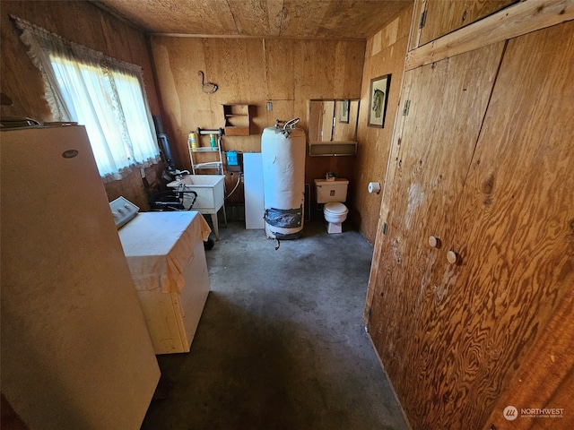 interior space featuring a sink, water heater, dark colored carpet, and light countertops