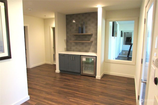 bar featuring gray cabinetry, beverage cooler, and dark hardwood / wood-style floors