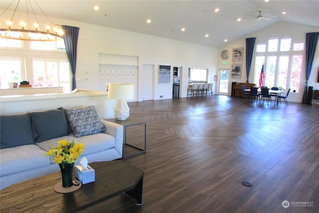 living room with dark parquet floors, a high ceiling, and ceiling fan with notable chandelier