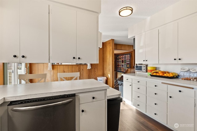 kitchen with wooden walls, dishwasher, and white cabinets