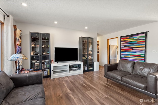 living room with hardwood / wood-style floors and a textured ceiling