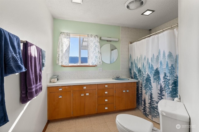 bathroom with curtained shower, vanity, a textured ceiling, and toilet