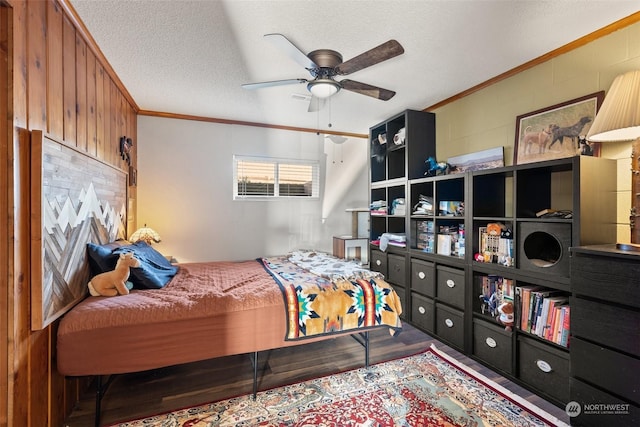 bedroom featuring hardwood / wood-style floors, ceiling fan, ornamental molding, and a textured ceiling