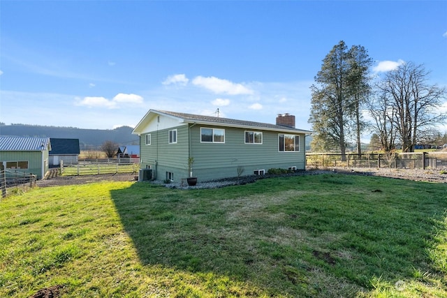 back of property with a lawn and cooling unit