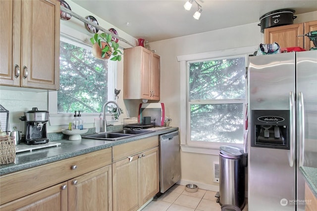 kitchen with appliances with stainless steel finishes, light tile patterned floors, light brown cabinetry, and sink