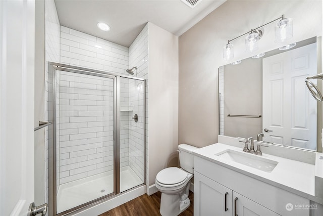 bathroom with vanity, hardwood / wood-style floors, walk in shower, and toilet