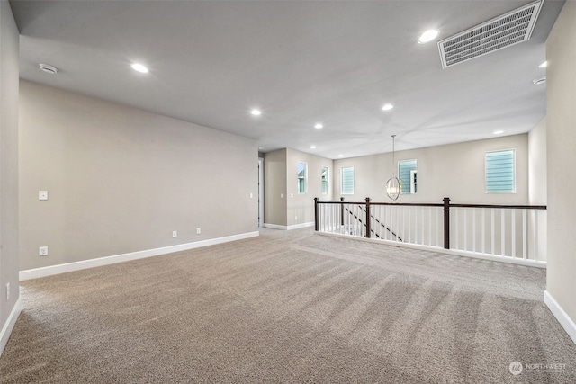 carpeted empty room with a chandelier